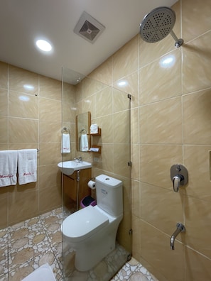 A bathroom with a toilet, sink, and shower. - Monty's Riverside View Resort by Cocotel (San Antonio)