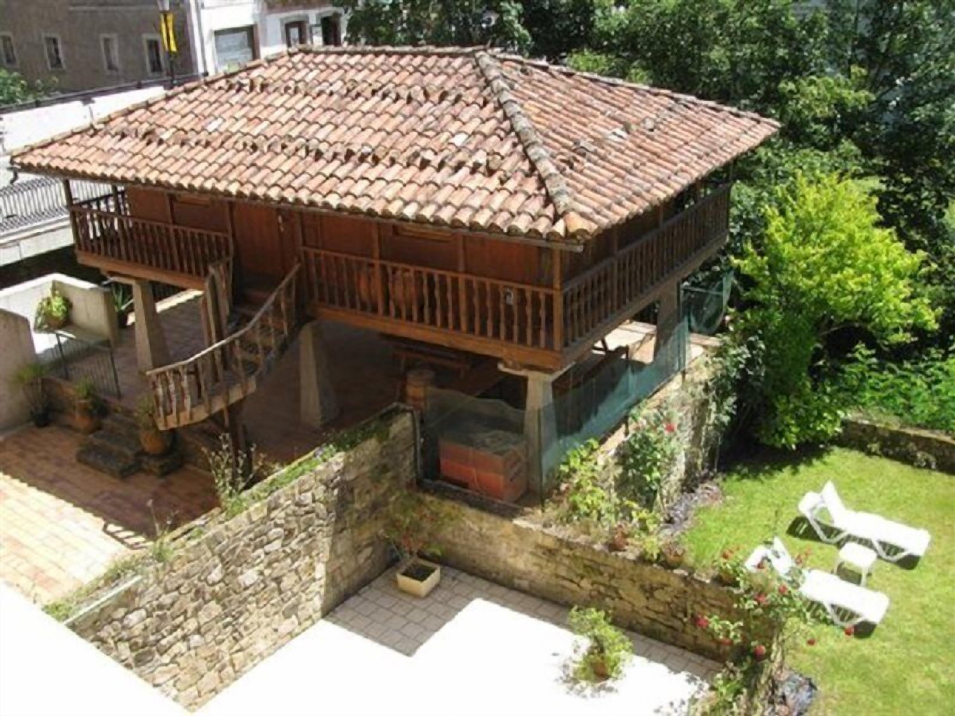 Un edificio de madera con techo de tejas, balcón y pared de piedra.