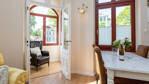 Un espace repas comprenant une table et des chaises, un canapé et une porte donnant sur un espace extérieur.