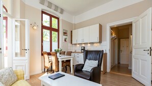 Un salon spacieux avec une table basse blanche, un canapé jaune et un fauteuil en cuir.