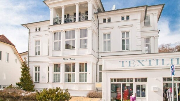 Ein weißes Gebäude mit Balkon und einem Schild, auf dem 'Villa Anna' steht.