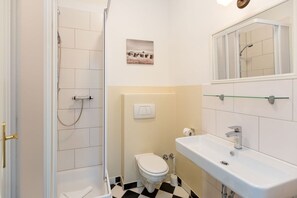 Un baño con ducha, inodoro y lavabo.