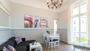 Un salon moderne avec un canapé, une table à manger et un lustre.