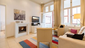 A modern living room with a fireplace, a television, and a comfortable seating area.