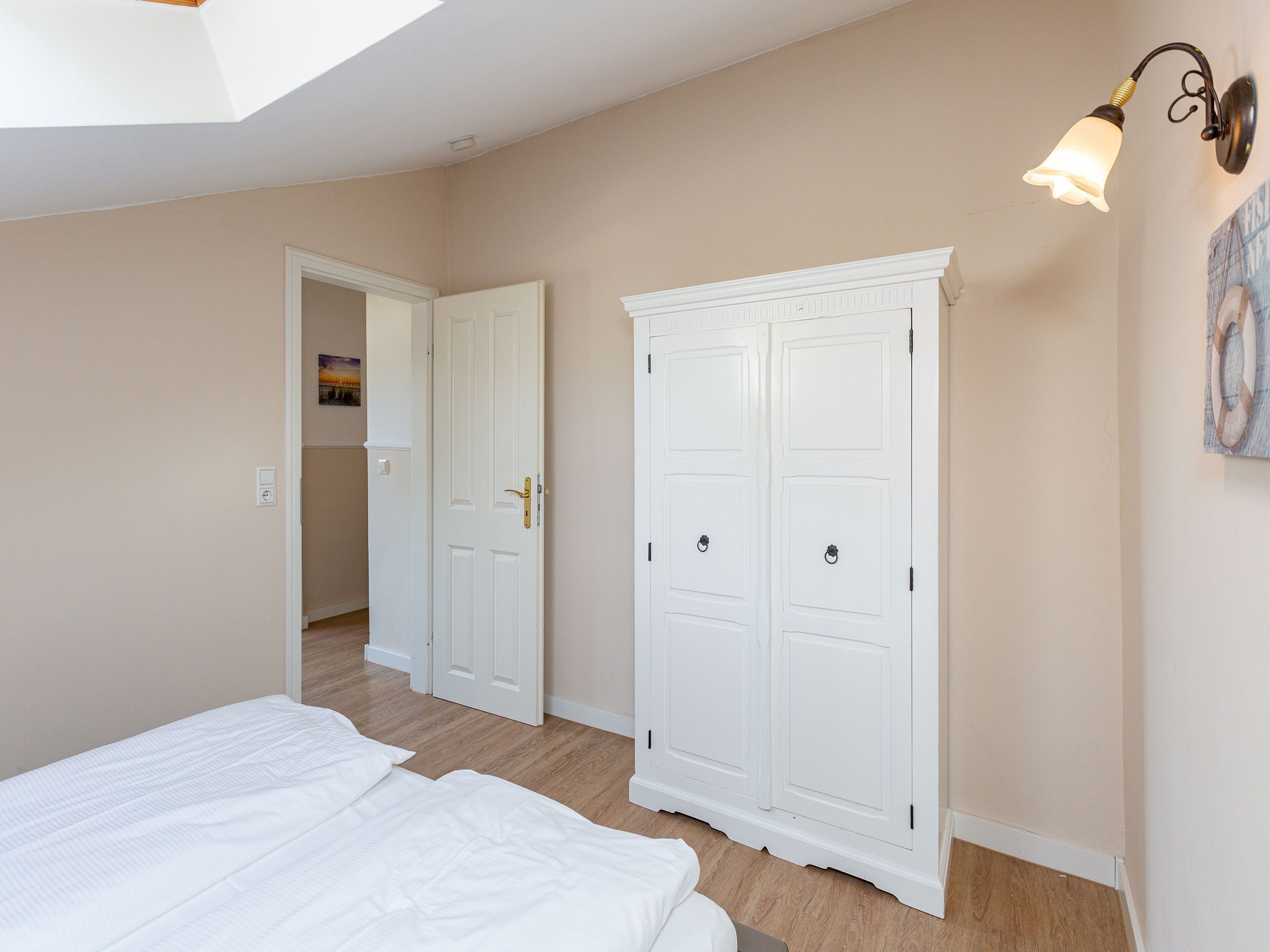 A bedroom with a bed, a wardrobe, and a ceiling light.