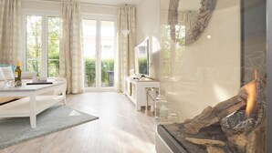 En moderne stue med pejs, sofa, sofabord og spiseplads.
