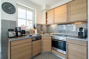 Eine moderne Küche mit Holzausstattung, Edelstahlgeräten und einem großen Fenster.