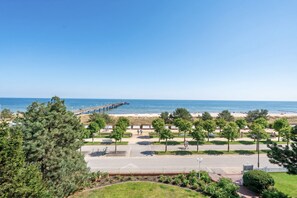 Ein Küstenpark mit einer Mole, Fußwegen und einem Strand.