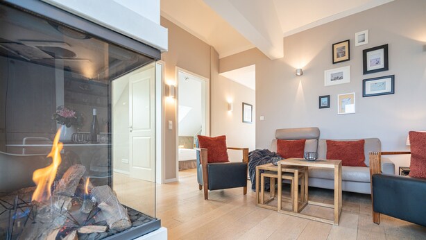 Una sala de estar moderna con chimenea, un juego de sofá y una mesa de centro.