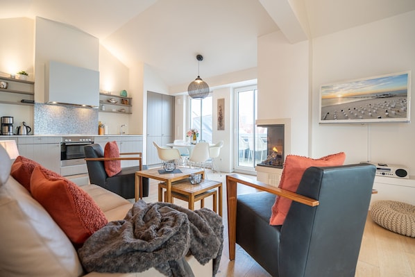 Un salon moderne avec un canapé, des fauteuils, une table basse et une cheminée.