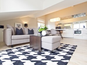 Ein modernes Wohnzimmer mit einer Couch, einem Couchtisch und einem Essbereich mit Stühlen.