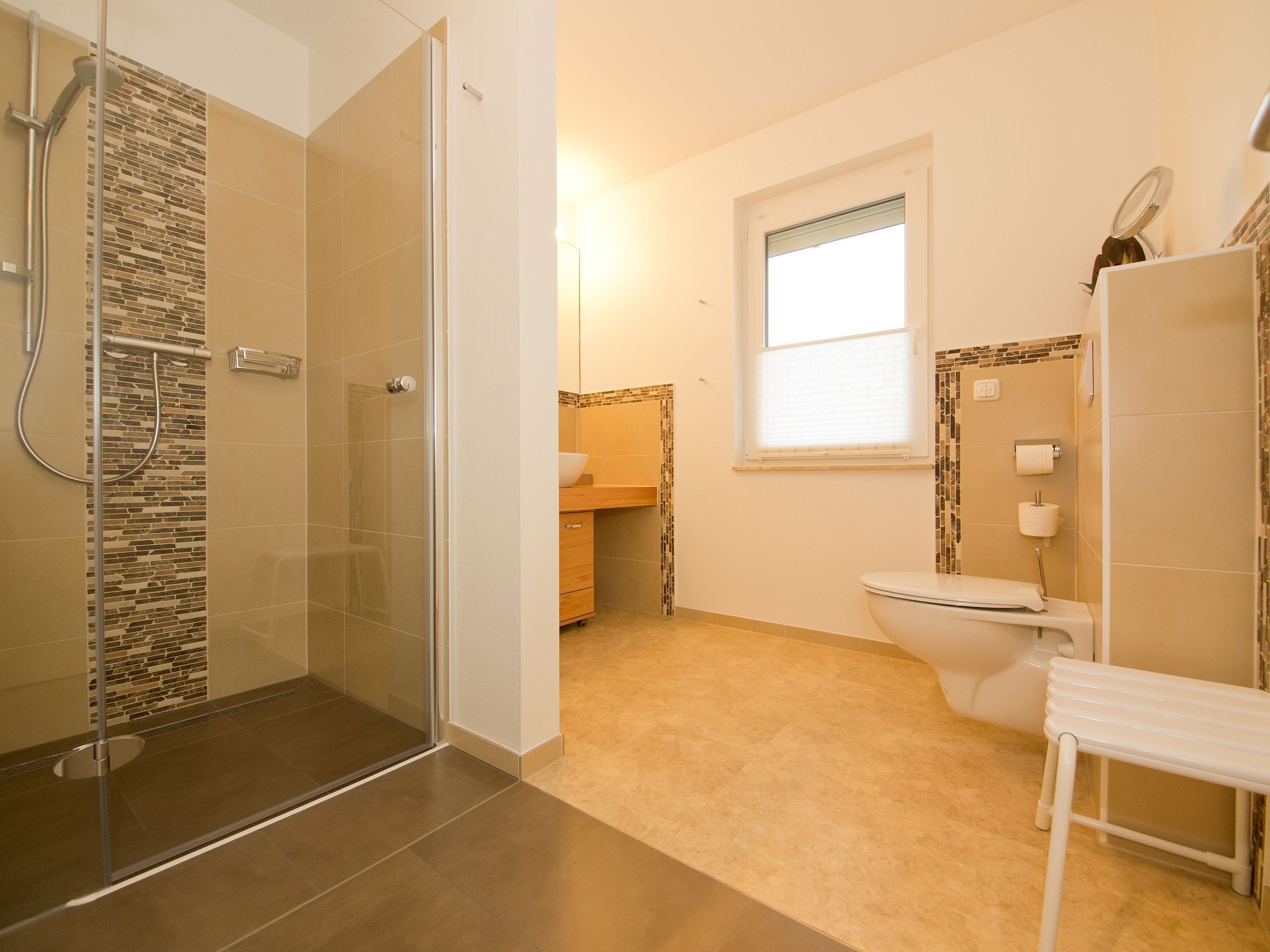 Une salle de bain avec douche, toilettes et lavabo.