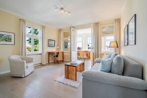 A spacious living room with a sofa, a dining table, and a coffee table. - The Villa, App. 9, Germany (Heringsdorf)
