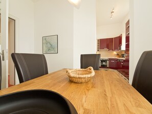 A dining area with a wooden table, black chairs, and a woven basket.
