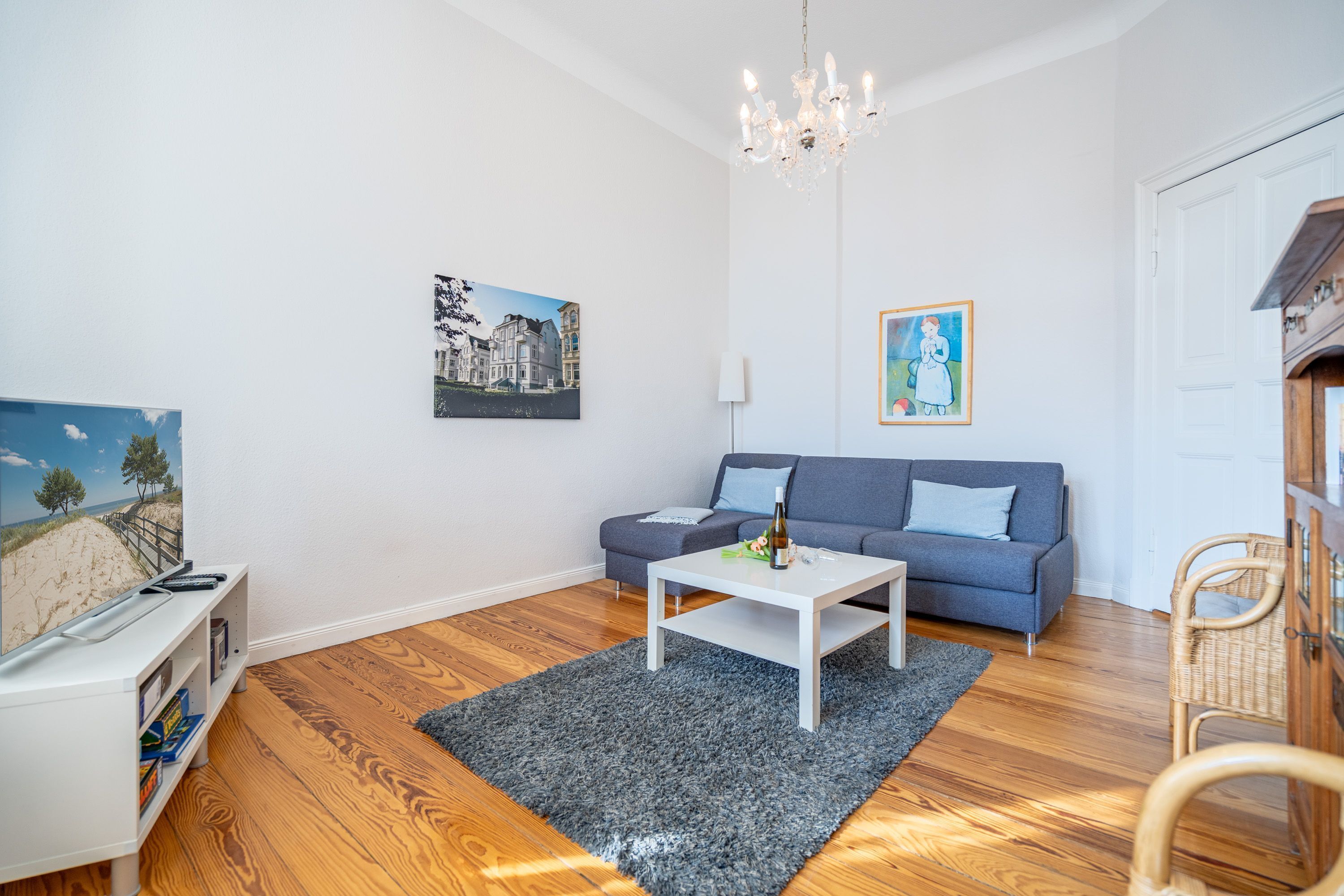 A living room with a sofa, coffee table, and a TV on a stand.