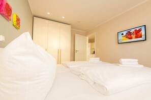 Ein Hotelzimmer mit zwei Betten, einem Kleiderschrank und einem Gemälde an der Wand.