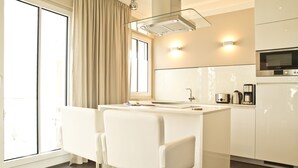 A modern kitchen with a central island, a built-in oven, and a microwave.