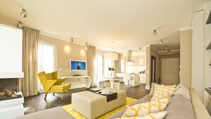 A modern living room with a sofa, yellow armchair, and a flat-screen TV.