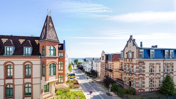 Et gadesyn med historiske bygninger, en klar himmel og en sti til fods.