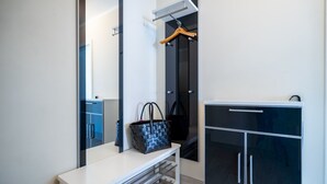 Un bagno moderno con un mobile vanitario bianco, un armadietto nero e un appendiabiti in legno a sospensione.