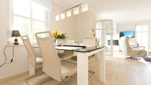 Un comedor moderno con una mesa, sillas y un jarrón de flores.