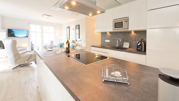 Una cocina moderna con una isla de vidrio, electrodomésticos de acero inoxidable y un diseño minimalista.