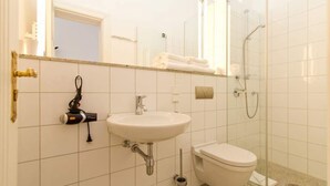 Une salle de bain avec un lavabo, des toilettes et une douche.