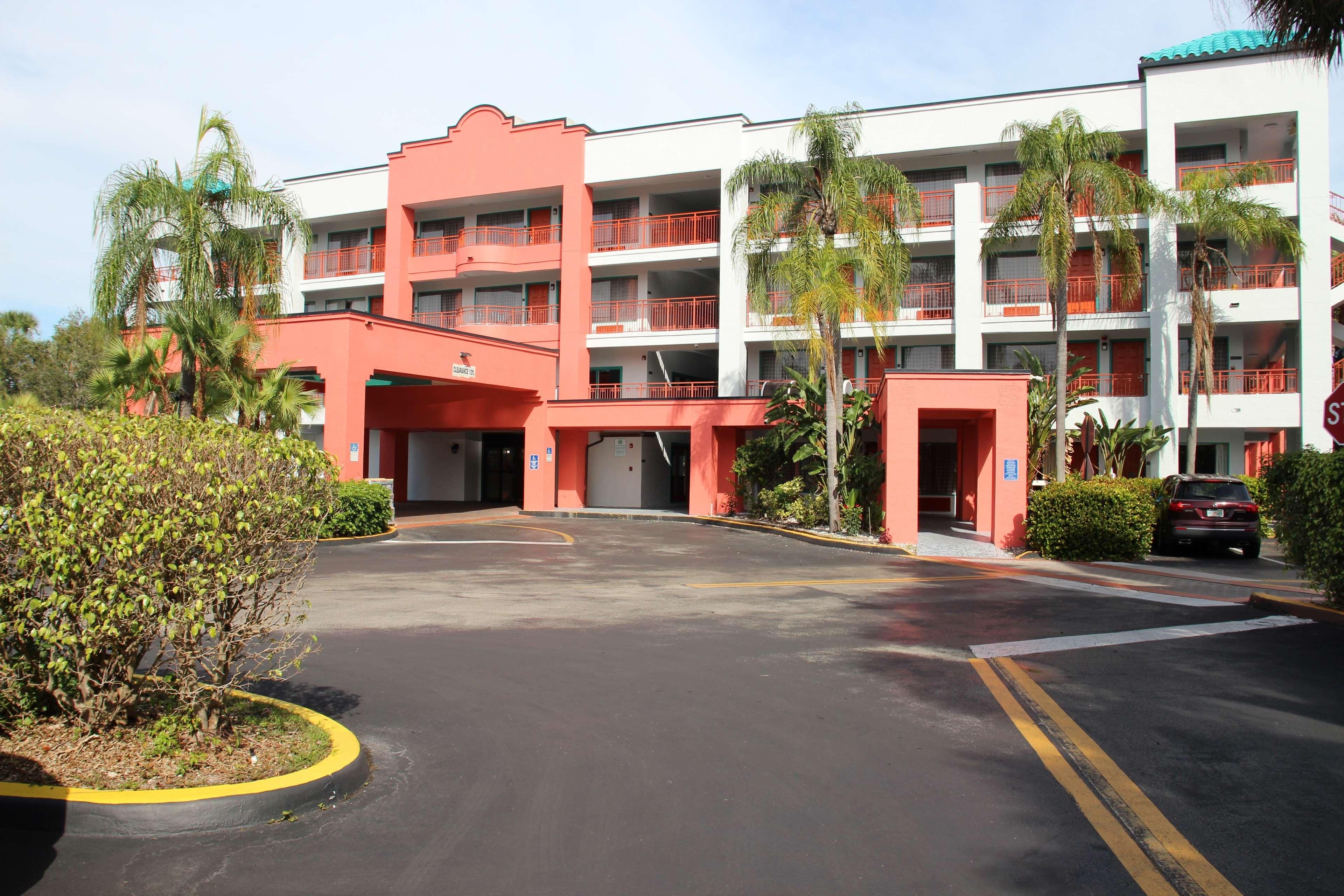 Un hôtel à plusieurs étages, doté d’une façade rouge et blanche, de nombreux balcons et d’un parking.