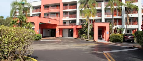 Un hôtel à plusieurs étages, doté d’une façade rouge et blanche, de nombreux balcons et d’un parking.