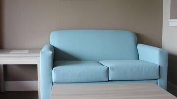 A light blue sofa, a white coffee table, and a framed picture on the wall.