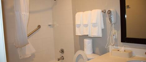 A bathroom with a bathtub, toilet, and sink.