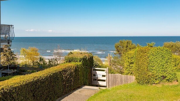 A coastal view with a wooden gate, a hedge, and a clear sky. - Haus am Kliff, App. 9 (Heringsdorf)