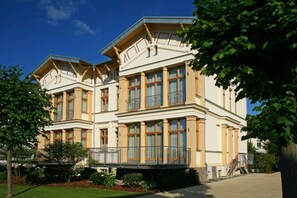 Ein großes, klassizistisches Gebäude mit mehreren Balkonen und großen Fenstern.
