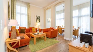 Un salon moderne comprenant un canapé, une table basse, un téléviseur et un coin repas avec une table et des chaises.