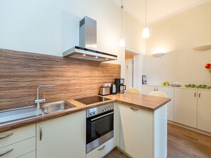 Een moderne keuken met een roestvrijstalen spoelbak, een inbouwoven en een houten aanrecht.