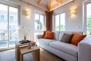 A modern living room with a sofa, a coffee table, and a view of the outside.