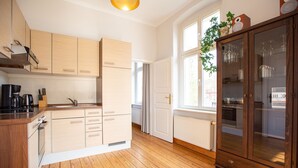A modern kitchen with wooden cabinets, a built-in oven, and a large wooden cabinet with glass doors. - House on the Hill, The Classic 03 (Heringsdorf)