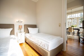 Une chambre d’hôtel avec deux lits, un bureau et une chaise.