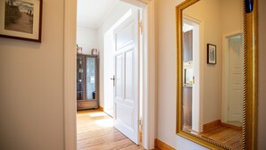 A hallway with wooden flooring, a large mirror, and a door leading to another room. - House on the Hill, The Classic 03 (Heringsdorf)