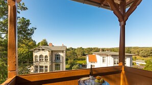 Ein Balkon mit Blick auf ein großes, verziertes Gebäude und umliegendes Grün.