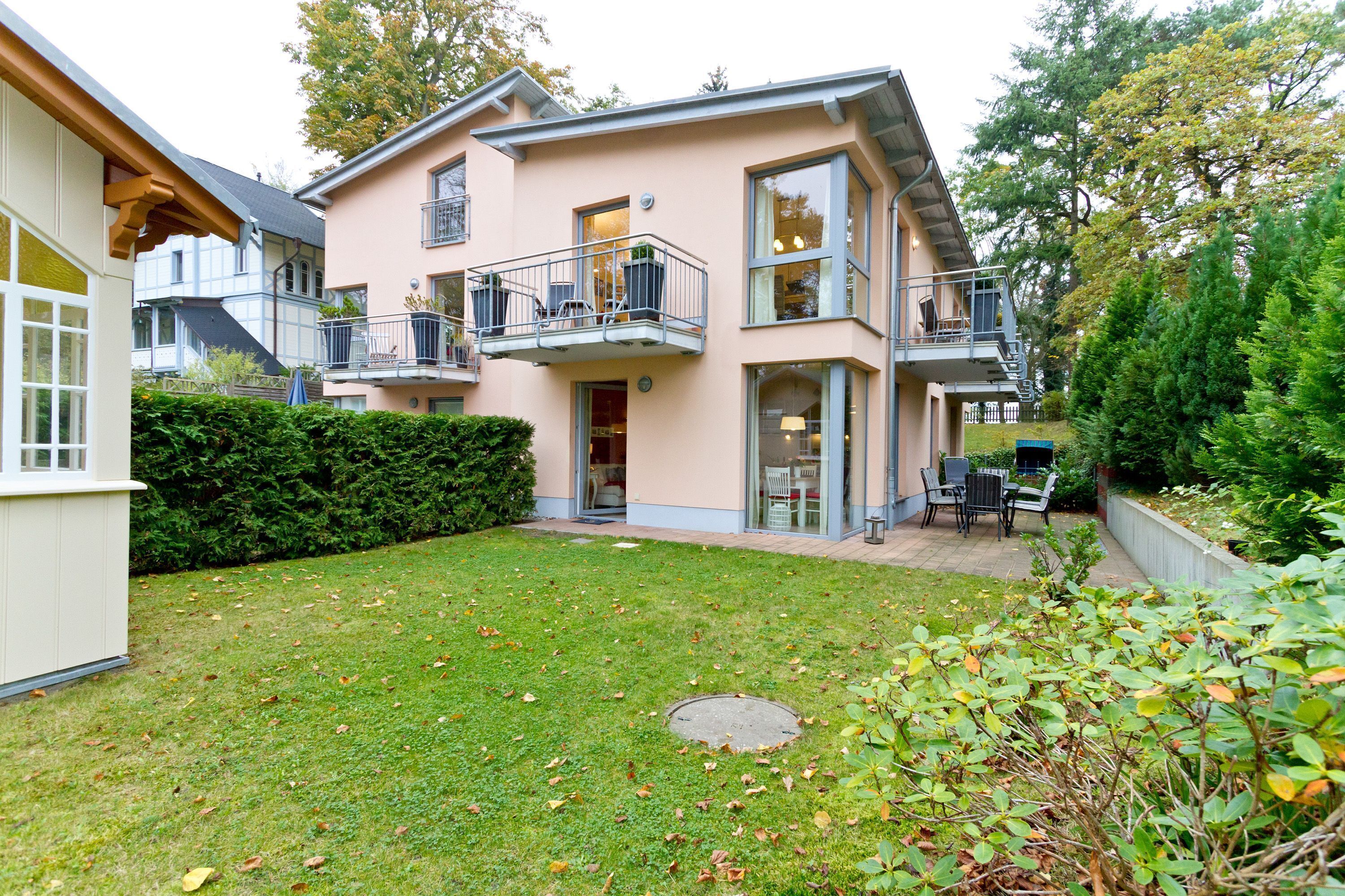 Ein zweistöckiges Haus mit Balkon, kleinem Garten und einem sichtbaren Gulideckel.