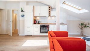 A modern kitchen with white cabinetry, a built-in oven, and a skylight. - Villa Hartmann-Drewitz, App. 08 (Heringsdorf)