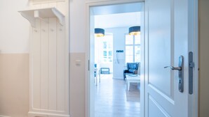 A hallway with a white door, a white wall, and a wooden floor. - Villa Hartmann-Drewitz, App. 03 (Heringsdorf)