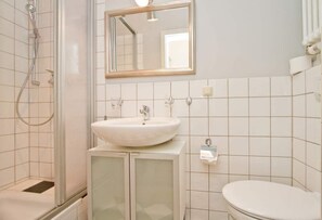 Ein Badezimmer mit Waschbecken, Spiegel und Toilette.