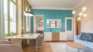 A modern living room with a sofa, a coffee table, and a dining area with a table and chairs. - Villa Frohsinn, app. 06 (Heringsdorf)