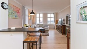 A modern kitchen with a dining area, a sofa, and a TV. - Villa Frisia, app. 30th (Heringsdorf)