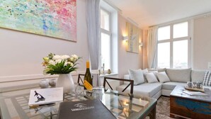 A modern living room with a glass coffee table, a sofa, and a decorative vase with flowers. - Villa Frisia, app. 30th (Heringsdorf)