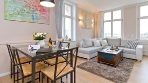 A modern living room with a glass dining table, a sofa set, and a decorative coffee table. - Villa Frisia, app. 30th (Heringsdorf)