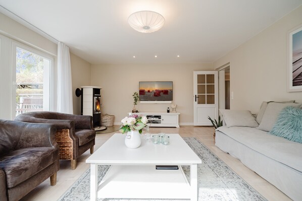 A modern living room with a white coffee table, brown leather sofa, and a white sofa.