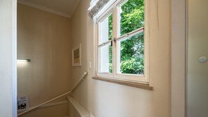 A hallway with a window, a door, and a light switch on the wall. - Villa Schlossbauer, App. 06 Remise (Heringsdorf)